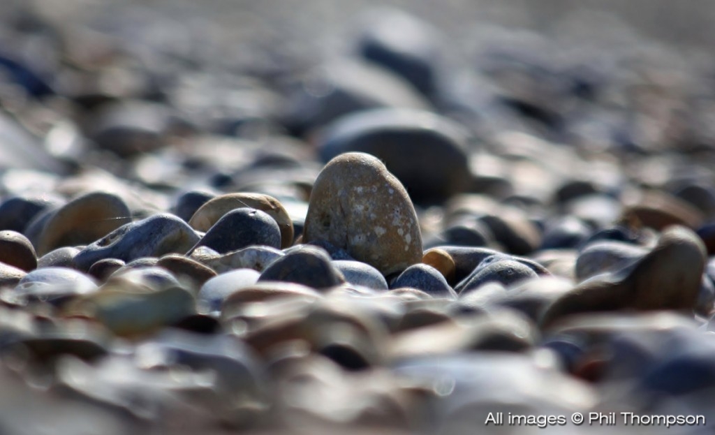 like pebbles on a beach, kicked around displaced by feet 